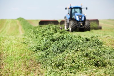 Image of a tractor bailing a hay field.