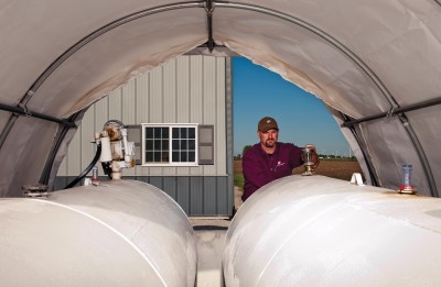 farmer inspecting outdoor fuel tanks